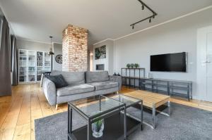 a living room with a couch and a flat screen tv at EXCLUSIVE Polonia Apartments in Szczecin