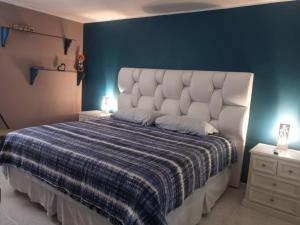 sypialnia z dużym łóżkiem z niebieską ścianą w obiekcie CALIFORNIA SUITE w mieście Caracas