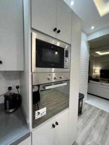 利雅德的住宿－شقة حديثه حي النرجس تسجيل ذاتي，厨房配有白色橱柜和微波炉