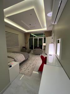 a bedroom with a bed and a red chair at شقة حديثه حي النرجس تسجيل ذاتي in Riyadh +11 photos