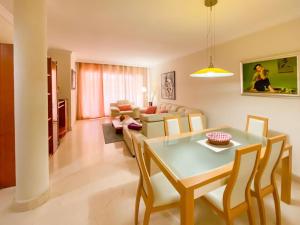 una sala da pranzo e un soggiorno con tavolo e sedie. di Apartamento en Los Patios de Santa Maria Golf a Marbella