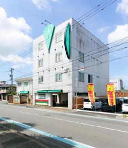 a building with a sign on the side of it at 福井・鯖江のホテル｜ホテルモーメント in Sabae