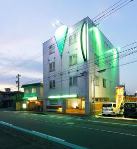 a building with a sign on the side of a street at 福井・鯖江のホテル｜ホテルモーメント in Sabae