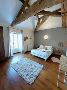 a bedroom with a bed and a white rug at Moulin de Monpoisson in Le Puy