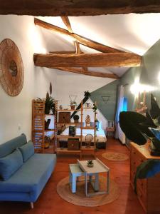 a living room with a blue couch and a bed at Moulin de Monpoisson in Le Puy