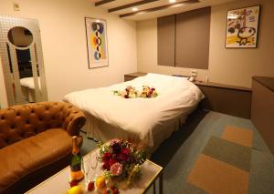 a hospital room with a bed with flowers on it at 福井・鯖江のホテル｜ホテルモーメント in Sabae