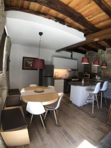 a kitchen and dining room with a table and chairs at Vila Cavalica in Bustelo
