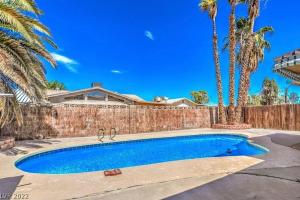 una piscina frente a una valla con palmeras en Molino en Las Vegas