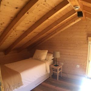 a bedroom with a bed in a wooden attic at Vila Espigueiro I in Bustelo