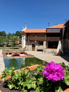 uma casa com piscina e flores rosas em Vila Espigueiro I em Bustelo