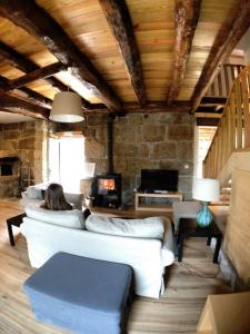a woman sitting on a couch in a living room at Vila Forno in Bustelo