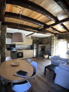 a kitchen and living room with a table and chairs at Vila Forno in Bustelo