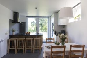 a kitchen with a table and some chairs and a counter at Vila Lagar in Bustelo