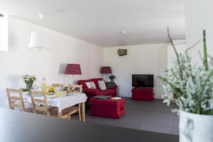 a living room with a table and a red couch at Vila Lagar in Bustelo