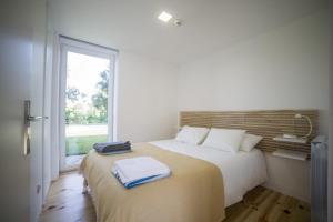 a bedroom with a large bed with a window at Vila Lagar in Bustelo +7 photos