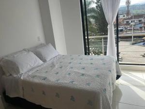 - une chambre avec un lit et une grande fenêtre dans l'établissement Magnifico apartamento, à Moniquirá