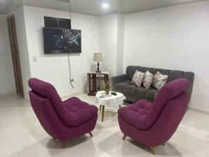 - un salon avec des fauteuils violets et un canapé dans l'établissement Magnifico apartamento, à Moniquirá