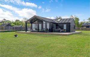 a small black house on a grass field at 3 Bedroom Beach Front Home In Kalundborg in Kalundborg