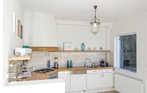 - une cuisine blanche avec évier et cuisinière dans l'établissement Nautilus 1, à Bergen aan Zee