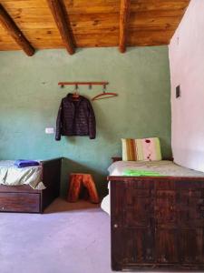 una habitación con una cama y una chaqueta colgada en la pared en Cabaña Santa Rita - Tilcara en Tilcara
