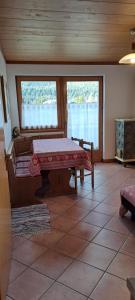 - un salon avec une table et 2 fenêtres dans l'établissement BALCONE SULLE DOLOMITI 2, à Dosoledo
