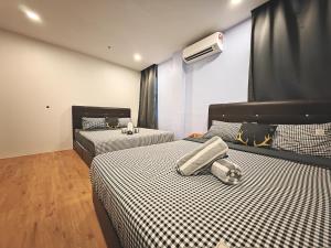 - une chambre avec 2 lits dotés de draps noirs et blancs dans l'établissement Karaoke & Snooker 14 ~ 18pax 4 min WALK to Jonker, à Malacca