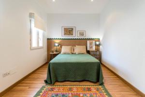 a bedroom with a bed with a green blanket at Piso céntrico San Simón in Santander