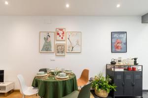 une salle à manger avec une table et des chaises vertes dans l'établissement Piso céntrico San Simón, à Santander