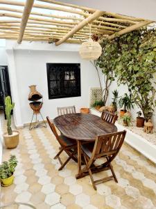a dining room with a wooden table and chairs at Desert Home Essaouira in Essaouira