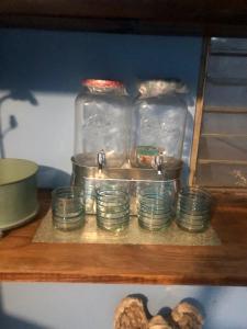 une étagère avec un bouquet de bols et de bocaux en verre dans l'établissement Cuarto azul, à Ciudad Valles