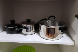 two pots and pans sitting on a shelf at Chesskings Guest House - Unit 2 in Winnipeg