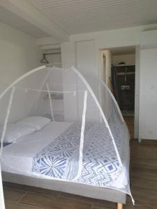 a bed with a canopy in a room at Appartement neuf et tout confort sur la Trinité in La Trinité