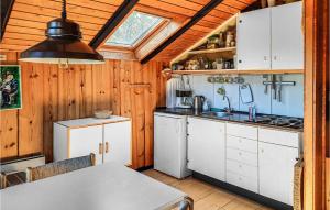 a kitchen with white cabinets and a ceiling with a window at Nice Home In Anholt With Kitchen in Anholt