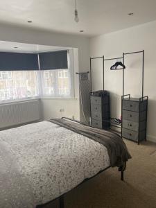 a bedroom with a bed and a dresser and a window at Hameway House- Stunning 4 bedroom house with a spacious kitchen in London