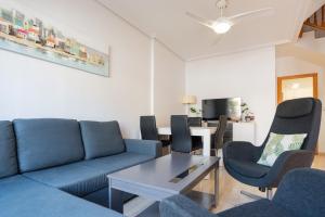 a living room with a blue couch and chairs at Casa Gris in Orihuela Costa