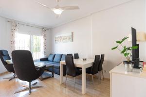 a living room with a table and chairs and a couch at Casa Gris in Orihuela Costa