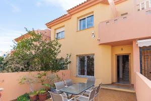 a patio with a table and chairs in front of a house at Casa Gris in Orihuela Costa
