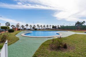 een zwembad in een park met palmbomen bij Casa Gris in Orihuela