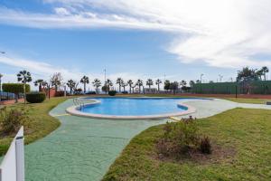 a swimming pool in a park with palm trees at Casa Gris in Orihuela Costa