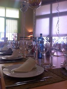 a dining room table filled with wine glasses and wine glasses at Pension Los Cisnes in Puerto de Mazarrón