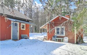 Cabaña roja con mesa y sillas en la nieve en Gorgeous Home In Enviken With Kitchen, en Enviken