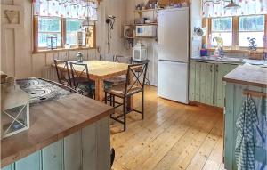 a kitchen with a table and a white refrigerator at Gorgeous Home In Enviken With Kitchen in Enviken
