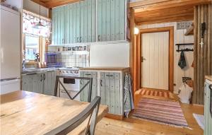 cocina con armarios verdes y mesa de madera en Gorgeous Home In Enviken With Kitchen, en Enviken
