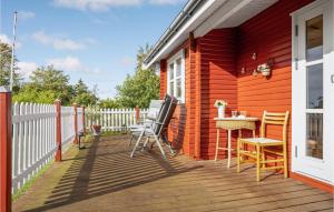 eine Terrasse mit Stühlen und einem Tisch auf einem Haus in der Unterkunft 1 Bedroom Awesome Home In Bog By in Bogø By