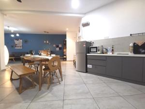 a kitchen and dining room with a table and a refrigerator at Galaxy 12~16pax Sea View I Wifi I 5min to Jonker in Melaka