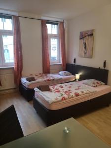 two beds in a room with two windows at Apartmentzimmer in Erfurt