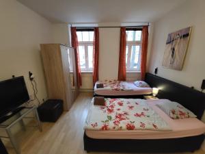 a room with two beds and a tv in it at Apartmentzimmer in Erfurt