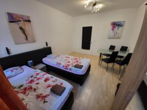 a room with two beds and a table and chairs at Apartmentzimmer in Erfurt