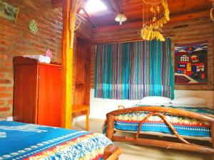 a bedroom with a bed and a wooden wall at Hospedaje Vertientes del Imbabura in Otavalo