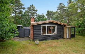 una pequeña casa negra con chimenea de ladrillo en Beautiful Home In Vig With Wifi, en Vig